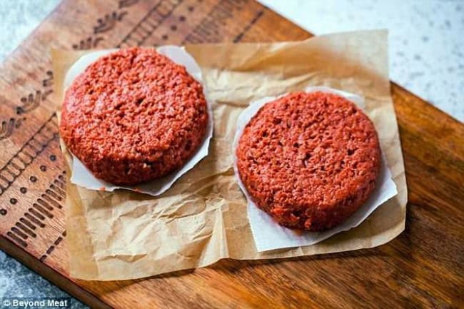 Juicy, flavorful beef burger patties on parchment paper, ready for grilling or cooking, showcased on a rustic wooden cutting board, perfect for comfort food and barbecue dishes.