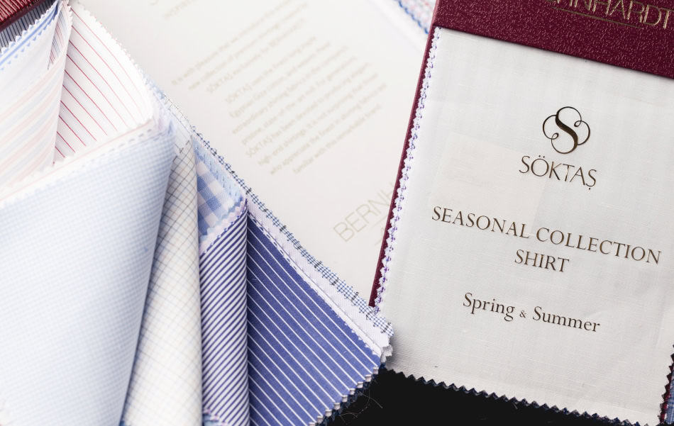 Light blue and white fabric swatches for men's dress shirts with various patterns, displayed alongside a fabric sample card from Soktas for the Spring & Summer collection.