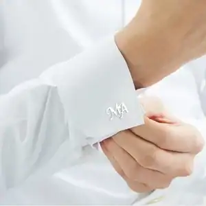 Shirt cuff with personalized monogram jewelry, elegant and stylish for formal occasions.