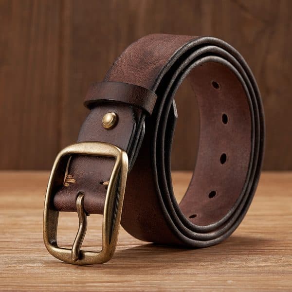 Brown leather belt with brass buckle on wooden surface, stylish men's fashion accessory.