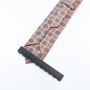 Elegant pink and blue patterned men's necktie with intricate design, paired with a decorative black measuring ruler for fashion and style accessories.