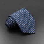 Elegant blue patterned silk tie with intricate geometric design, perfect for formal occasions and professional attire.