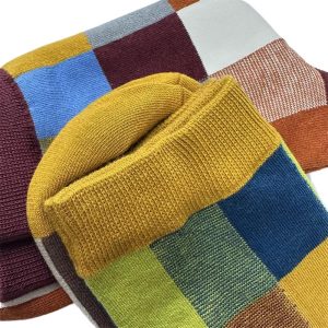 Colorful plaid knit socks with yellow, blue, green, and red patterns, showcasing vibrant wool material for comfortable, casual wear.