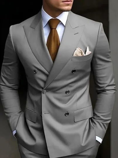 Elegant man in a tailored gray suit with a brown tie and pocket square, showcasing sophisticated men's fashion and business attire.