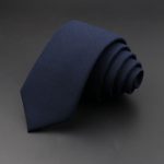 Elegant navy blue men's dress tie on a dark background, perfect for formal occasions and professional attire. Crafted from high-quality fabric, adding sophistication to any outfit.
