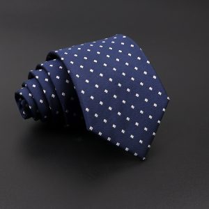 Luxurious navy blue men's tie with white geometric dot pattern, perfect for formal occasions and professional attire.