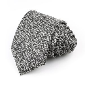Soft black and white patterned men's dress sock neatly rolled, showcasing stylish and comfortable accessory.