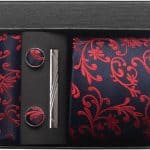 Elegant men's gift set with navy and red floral pocket square, silver tie clip, and matching cufflinks in a stylish black box, perfect for special occasions and formal attire.
