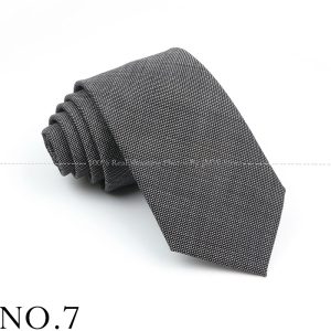 Luxurious black and white patterned men's tie, elegantly rolled for display, perfect for formal occasions and professional attire.