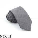 Elegant gray checkered men's necktie with stylish pattern, perfect for formal occasions and professional attire. High-quality fabric and classic design offer timeless sophistication.