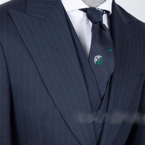 Pinstripe navy suit with white dress shirt and dark tie featuring the DeoVeritas logo, highlighting professional men's fashion and branding.