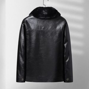 Black leather shearling-lined jacket hanging on a wall hook, stylish winter outerwear with a fur collar for warmth and luxury.