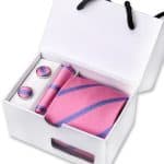 Pink striped men's accessory gift set featuring a tie, cufflinks, and lapel pin in a white box, ideal for stylish formal occasions and wedding attire.