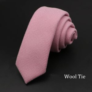 Soft pink wool tie with a subtle checkered pattern, rolled neatly on a black background, ideal for formal and professional menswear. Perfect for business attire and special occasions.